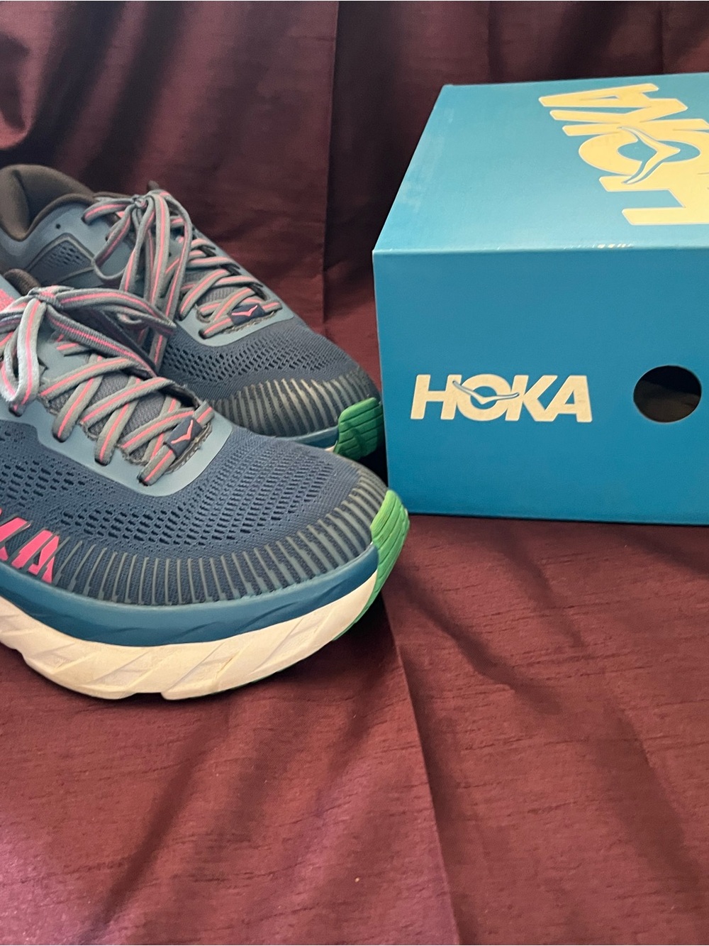 Hoka navy blue running shoes with pink and green accents